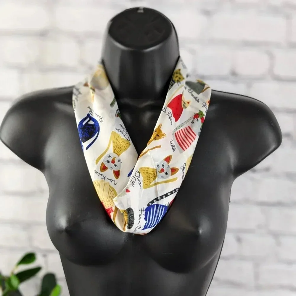 Assorted colorful whimsical cats on white background with gold trim scarf